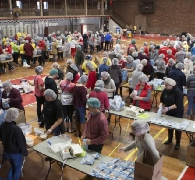 students doing community service filling boxes of food for those in need