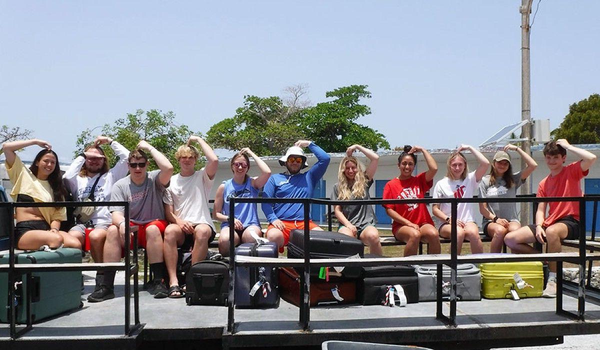 Students on a truck with their previously missing luggage