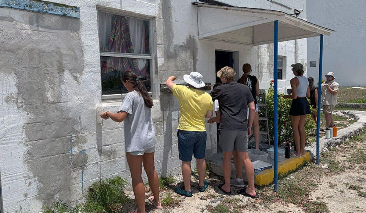 Students painting a building as service to the GRC