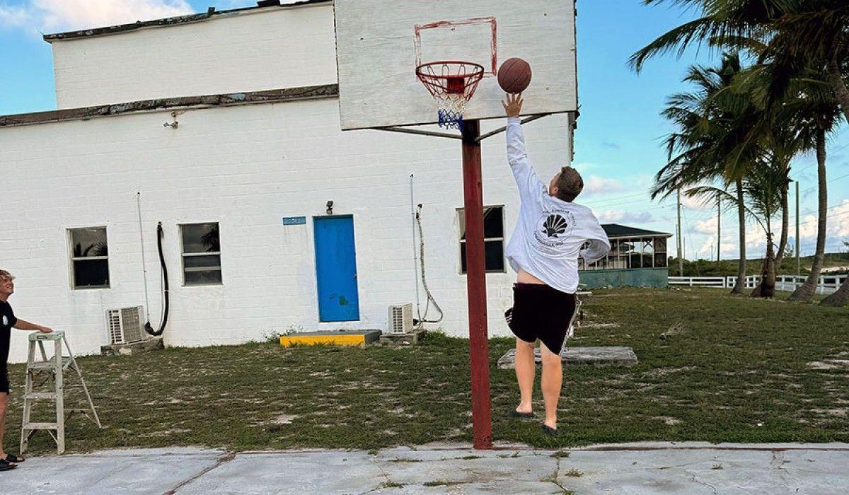 A student shoots a basketball at a hoop